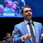 Flávio Bolsonaro defende privatização dos Correios e critica ineficiência da estatal em entrevista à rádio